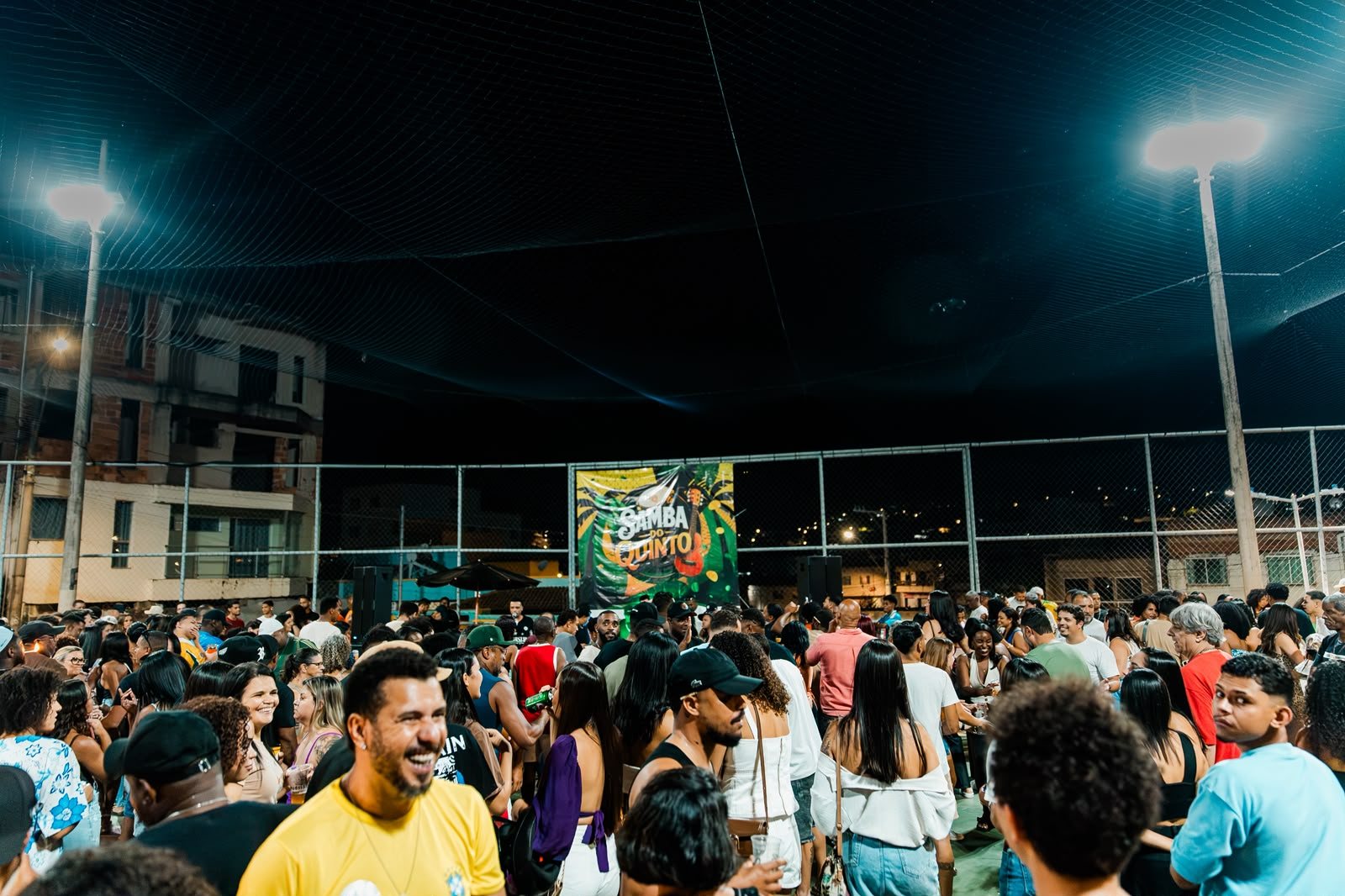 Público reunido na quadra diante do banner do Samba do Quinto, sob a luz dos refletores